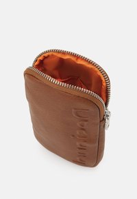 Mała brązowa skórzana saszetka z wytłoczonym logo, otwarty srebrny zamek błyskawiczny i jaskrawoopalizujące wyściółka w kolorze pomarańczowym.