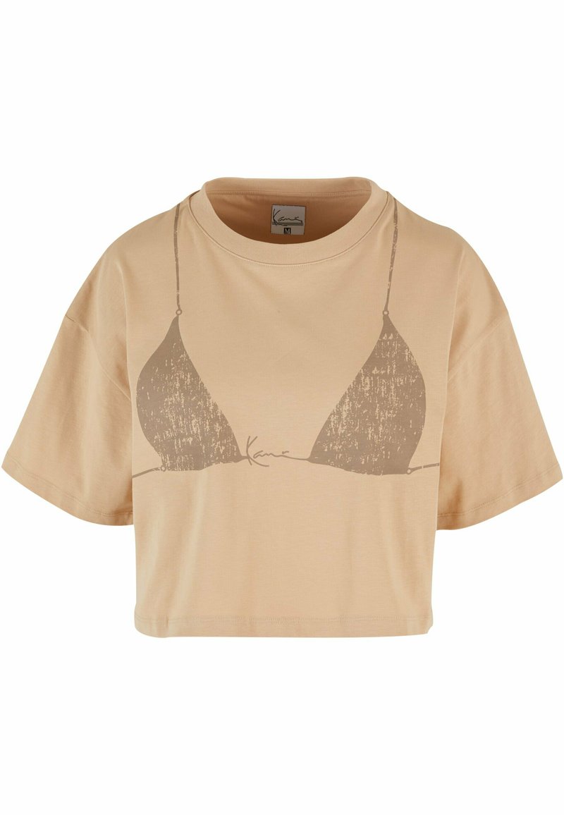Avskåret, beige bomulls t-skjorte med et minimalistisk grafisk design av en bikini overdel i en mørkere nyanse. Korte ermer og rund hals.