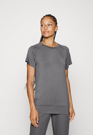 Grey short-sleeve athletic top with a round neckline, soft texture, and subtle seam detailing; paired with matching grey pants.