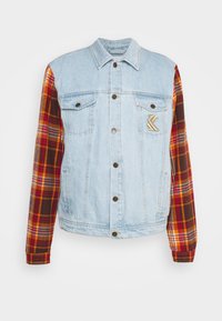 Denim jacket with light blue body and plaid sleeves in red, orange, and brown. Features button closure and chest pocket with logo detail.