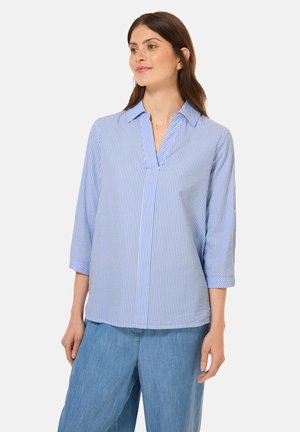 Blau-weißer gestreifter Langarmshirt mit Kragen und V-Ausschnitt. Weicher Stoff mit lockerer Passform, kombiniert mit hellblauen weit geschnittenen Hosen.