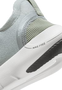 Nike Free shoes feature a gray and green textile upper with a smooth, textured finish, a white midsole, and a black rubber outsole.