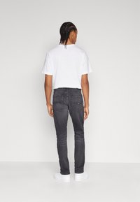 Tommy Jeans SCANTON SLIM - Prigludę džinsai - denim black