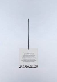Ετικέτα ενδύματος με μαύρο κορδόνι, επισημασμένη "Ειδική Επεξεργασία," που εξηγεί τη μοναδική διαδικασία βαφής και τις οδηγίες φροντίδας, με την ονομασία του εμπορικού σήματος "NAPAPIJRI" στο κάτω μέρος.