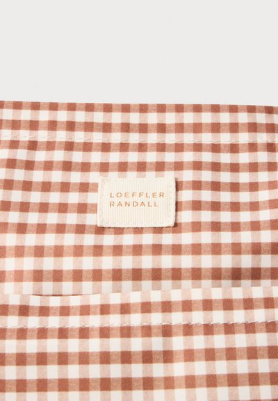 Țesătură gingham maro și albă cu modele cu carouri mici, având o etichetă Loeffler Randall vizibil cusută în material.