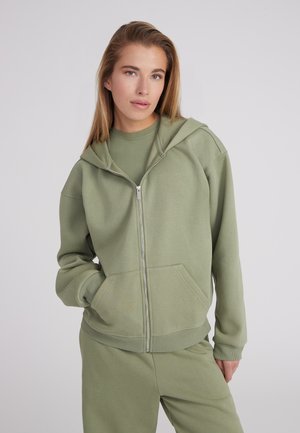 Lichtgroene zip-up hoodie gemaakt van zacht materiaal, met een voorkantzak, een capuchon met trekkoord en ribbelboorden bij de mouwen en onderkant.
