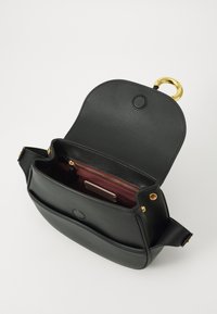 Borsa in pelle nera con patta arrotondata e hardware dorato, dotata di una tasca interna rossa e una tasca frontale per l'organizzazione.