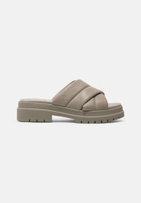 Sandalo scivoloso beige con cinturini in pelle intrecciati, soletta imbottita e una suola spessa e testurizzata di colore verde oliva per una migliore aderenza.