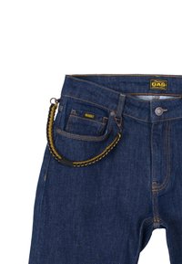 Jeans in denim blu scuro con cuciture gialle, caratterizzati da un patch con il logo GASS, chiusura frontale con bottone e una decorativa catena nera e gialla.