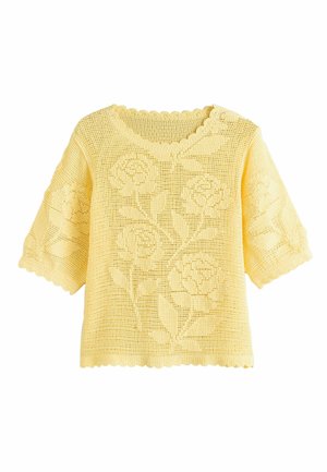 Yellow knitted short-sleeve top with floral patterns, scalloped neckline and hem, and a loose, open-weave design.