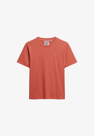 T-shirt à manches courtes en coton corail avec un col rond. Présente un logo brodé à l'avant et une coupe décontractée. Texture lisse, sans motifs.