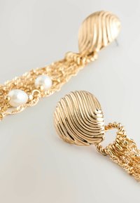 Gold-tone earrings featuring a shell-shaped top with ribbed design, hanging strands of twisted metal, and three small pearls.