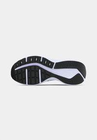 Μαύρη και λευκή εξωτερική σόλα από καουτσούκ αθλητικού παπουτσιού με τμηματική χάραξη και υφή για καλύτερη πρόσφυση σε απλό ανοιχτόχρωμο φόντο.