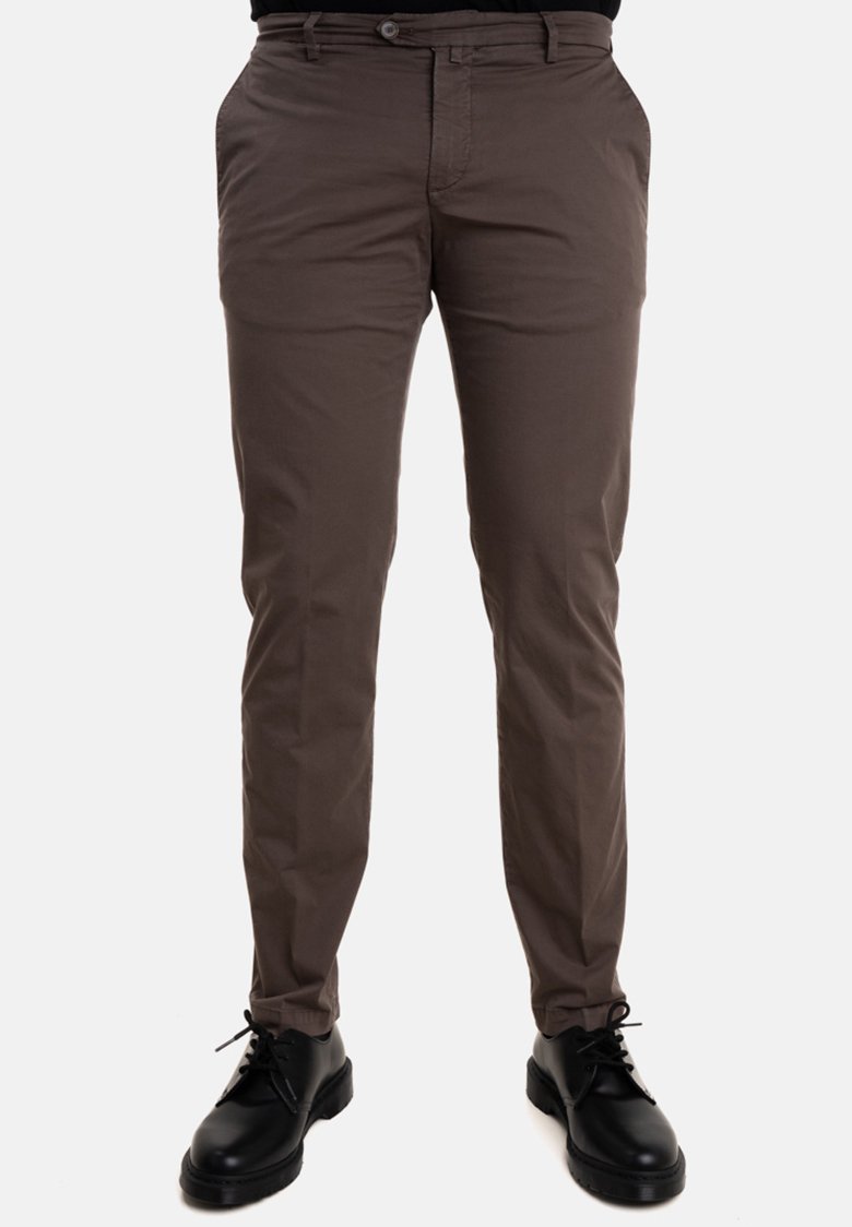 Pantaloni di cotone marroni con una vestibilità slim, dotati di tasche laterali e passanti per cintura, abbinati a scarpe nere stringate con suola spessa.