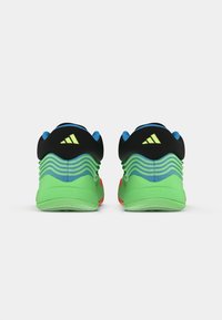 Athletic shoes with a black upper, green and blue accents, textured heel, and vibrant red sole. Features three distinctive stripes.