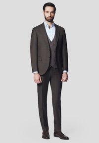 Brąsnowy garnitur trzyczęściowy z teksturowaną kamizelką, połączony z jasnoniebieską koszulą i brązowymi butami. Dopasowany krój o nowoczesnym designie.