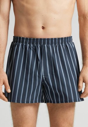 Boxers bleu marine avec des rayures verticales bleu clair, taille élastique et coupe décontractée. Fabriqués à partir d'un tissu lisse et léger.