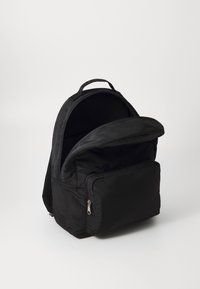 Černý nylonový batoh s kapsou na zip na přední straně, horní rukojetí, polstrovanými ramenními popruhy a prostornou hlavní komorou. Hladký povrch.