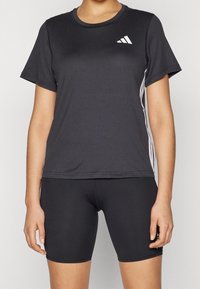 Czarny sportowy T-shirt z krótkimi rękawami, z białymi paskami po bokach i małym białym logo na piersi. Gładka tekstura.