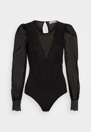 Zwarte bodysuit met sheer, gestippelde lange mouwen, v-vormige kanten halslijn en een aansluitende lijf die is voorzien van naaddetails. Keyhole sluiting aan de achterkant.