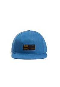 Gorra de denim azul con visera plana, que presenta una etiqueta negra con texto amarillo que incluye el logo "VANS ORIGINAL" y las instrucciones de cuidado.