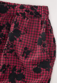 Țesătură în carouri roșu și negru, cu un model floral, textură moale și talie adunată. Potrivită pentru uz casual.