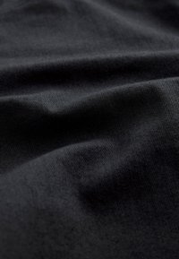 Melns audums ar mīkstu tekstūru un maigu aušanas rakstu, izceļoties ar maigu krāsu un dziļumu, piemērots dažādām lietojumprogrammām.