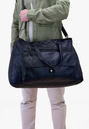 Large black leather duffel bag with top zip closure, dual handles, and adjustable shoulder strap. Features front pocket and subtle stitching.