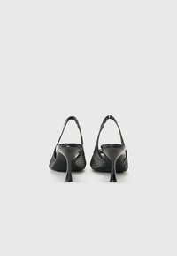 Musta tukikenkä, jossa on verkkokangas, terävä kärkinen muoto ja korkea stiletto-korko. Features a sleek, shiny finish ja teksturoitu yksityiskohta.