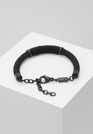 Black braided cord bracelet with black metal chain, lobster clasp, and a small rectangular tag engraved with "BREIL."