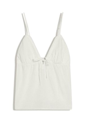 Witte mouwloze top met dunne dubbele bandjes, een diepe V-hals en een klein strikdetail aan de voorkant onder de buste.