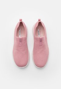 Zapatillas rosas tipo slip-on con parte superior de punto, que presentan un diseño texturizado y flexible, soporte elástico en el tobillo y suela blanca acolchada.