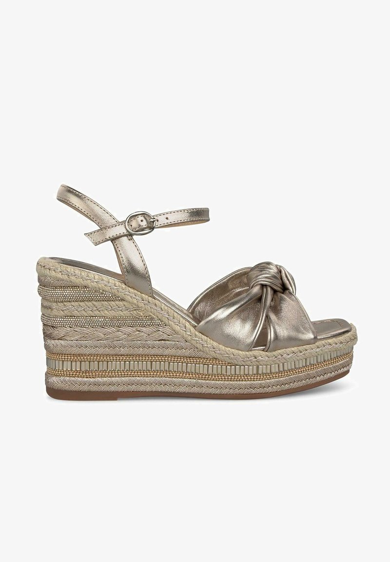 Metaalachtige bronzen wedge sandalen met een knoopontwerp aan de voorkant, verstelbare enkelriem en een getextureerde gevlochten hielafwerking. Lichtgewicht en open tenen.