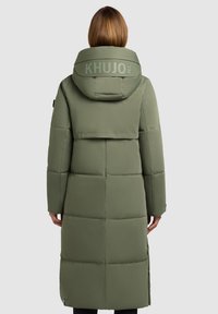 Olive roheline polsterdatud parka suure kapuutsiga, millel on seljal logo, horisontaalsed õmblused ja pikk siluett.