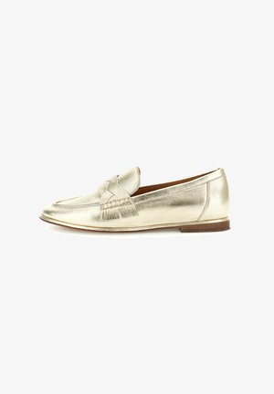 Metalen gouden leren loafer met gevlochten en franjerijke details, platte bruine zool en afgeronde neus.