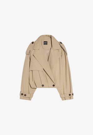 Beige cropped trenchcoat met een dubbele knoopsluiting, brede revers, schouderepauletten en gebuttoncuffjes. Gladde stoftextuur.