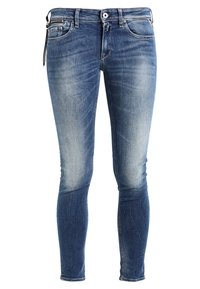 Jeans skinny de mezclilla azul con un lavado desgastado, que presentan un diseño de cuatro bolsillos, botón de latón y presillas para cinturón; textura suave con ligeras arrugas.