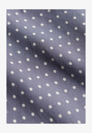 Blauwe stof met kleine witte stippen, toont textuur en lichte kreukels.