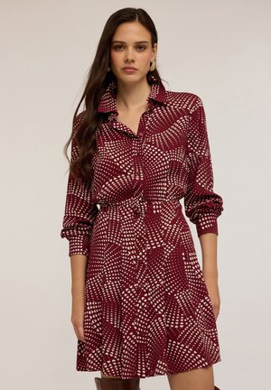 Rotes gemustertes Hemdkleid mit Kragen, langen Ärmeln, Knopfverschluss und taillierter Passform; das Design verfügt über weiße Punkte und Herzformen.