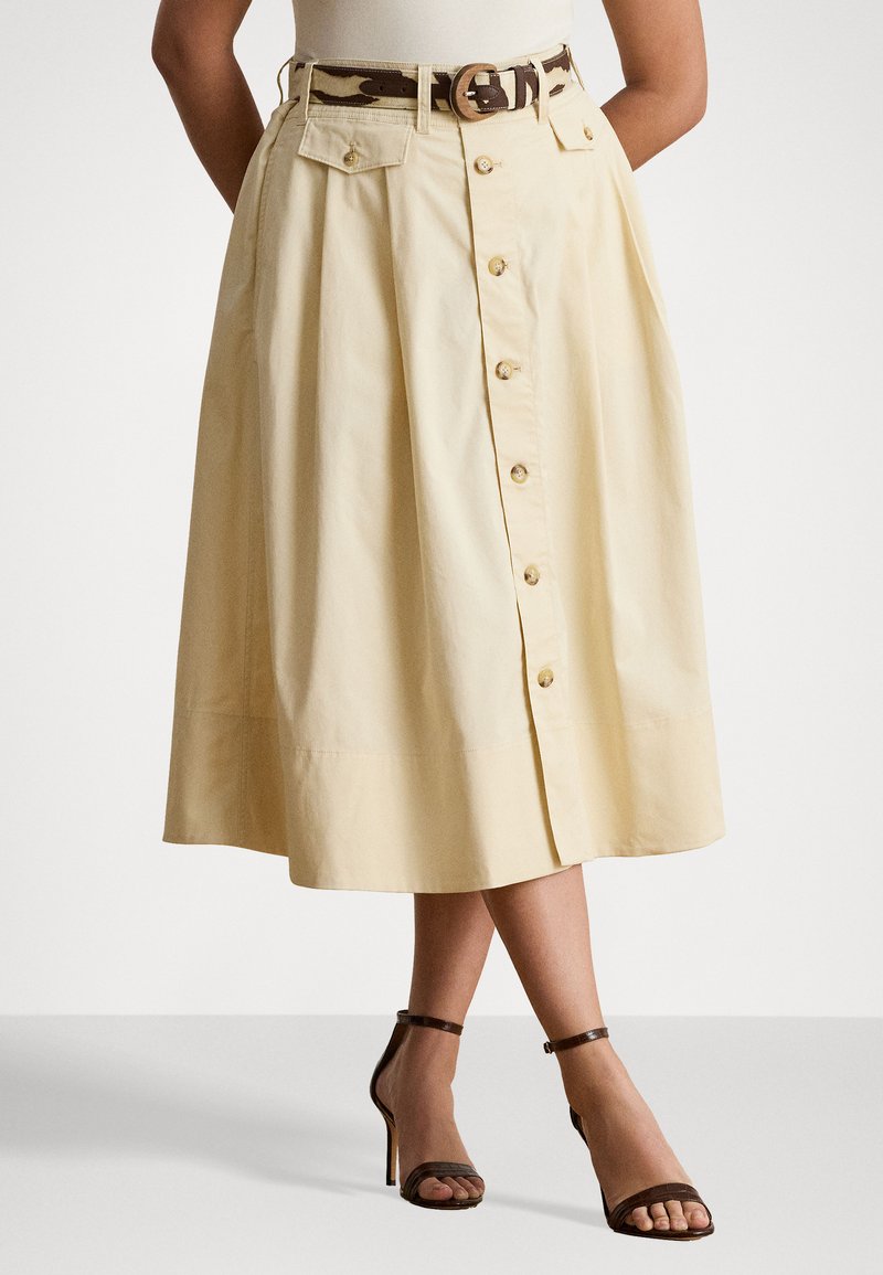 Gonna A-line gialla chiara in cotone, con abbottonatura frontale, tasche laterali e una cintura a fantasia marrone e beige.