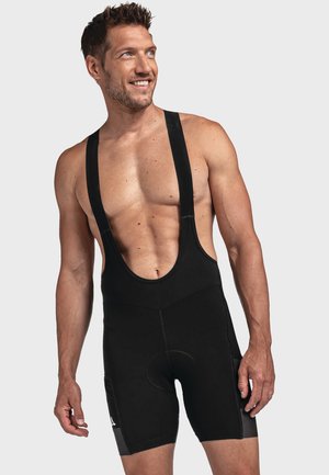 Schwarze Radhosen mit Trägern und ärmellosem Design, breiten Trägern, einem gepolsterten Sitzbereich und einer glatten, dehnbaren Stoffstruktur.