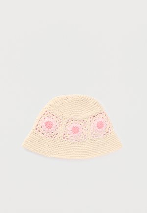 Chapeau bob en crochet crème avec des motifs floraux carrés rose et rose clair autour de la couronne.