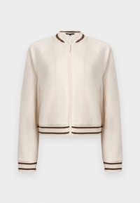 Veste zippée couleur crème avec poignets, col et ourlet côtelés à rayures marron et blanches, présentée sur un fond uni.