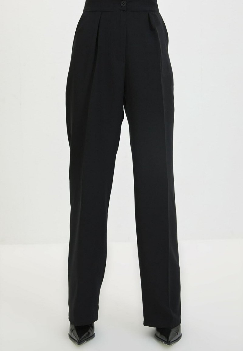 Pantalon noir taille haute avec plis, fermeture à bouton et jambes larges. Confectionné dans un tissu lisse avec un design minimaliste.
