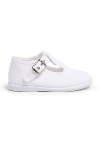 Bílé plátěné boty s T-popruhem, které mají malou stříbrnou sponu a plochou gumovou podrážku, hladkou texturu a minimalistický styl.