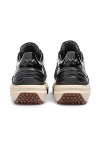 Schwarze Sneaker mit glänzender Oberfläche, strukturierten Akzenten und einer kontrastierenden beige Sohle. Die Rückansicht zeigt einen gepolsterten Kragen und ein gemustertes Profil.