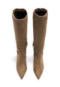 Botas de ante marrón hasta la rodilla con punta afilada y ajuste ceñido, que cuentan con cremallera en el lado exterior para facilitar el uso.