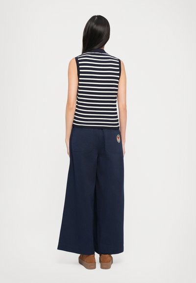 Navy and white striped sleeveless top with a collared neckline paired with wide-leg navy pants featuring back pockets and an embroidered design.