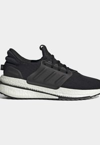 Basket sportive noire avec semelle blanche coussinée, grip texturé et cage à lacets en plastique noir intégrée sur fond neutre.