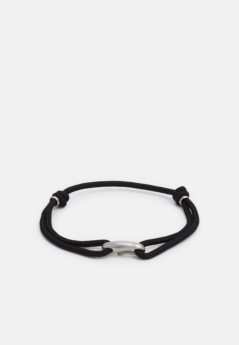 Bracelet cordon noir réglable avec un fermoir métallique incurvé argenté sur fond blanc.
